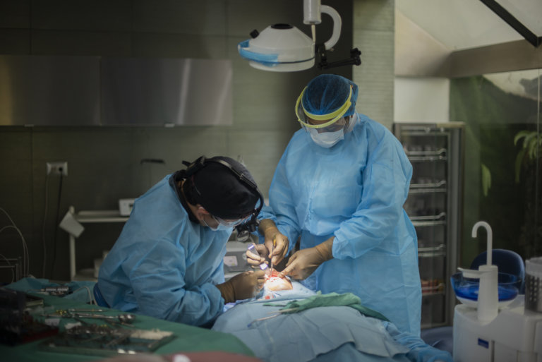 Odontólogos realizando procedimiento quirúrgico